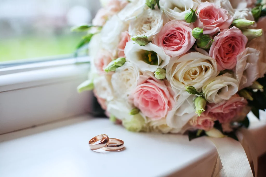 Ein Blumenstraß und Ringe, die Liebe und Hochzeit repräsentieren.
