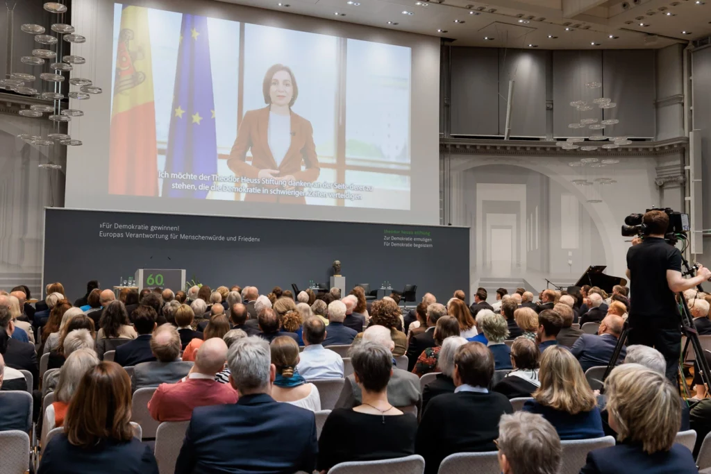 Präsidentin Maia Sandu auf einer Leinwand, vor ihr das Publikum der Verleihung des 60. Theodor Heuss Preises.